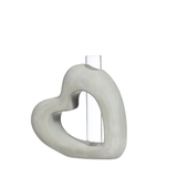 Heart-shaped concrete object with a clear cylindrical center on a white background
